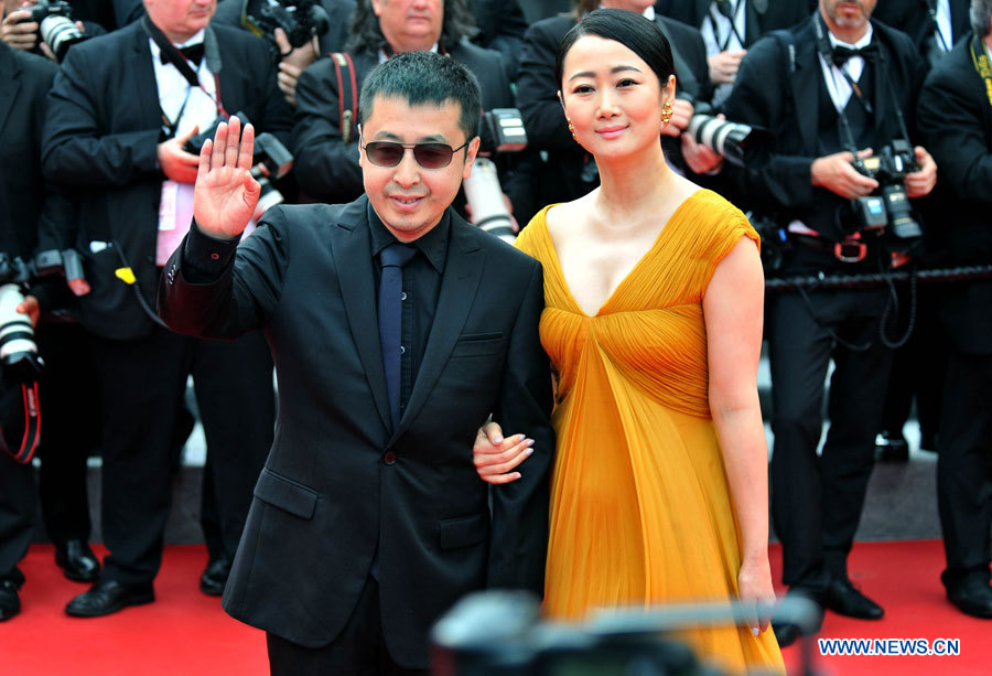 Le réalisateur chinois Jia Zhangke (à droite) arrive sur le tapis rouge avec son épouse Zhao Tao pour la projection du film "The Search" lors du 67e Festival de Cannes, le 21 mai 2014.