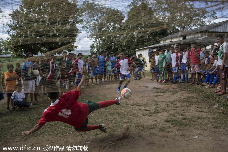 Ils sont plusieurs à assister à l’impuissance d’ un gardien de but devant un penalty, lors d’un tournoi de football dans la communauté de Sao Pedro, près de Manaus, au Brésil, le 18 mai 2014. Manaus est l’une des villes hôtes de la Coupe du Monde 2014 au Brésil. [Photo/IC]