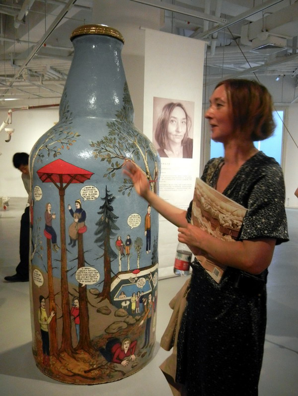 L'artiste norvégienne Ingrid Askeland présente son œuvre en céramique « Pourquoi prendre une gorgée si on peut faire cul-sec ? », au Musée d’Art du Lac Jinji de Suzhou, le 24 mai 2014. [Photo Wang Jiankang / asianewsphoto.com]