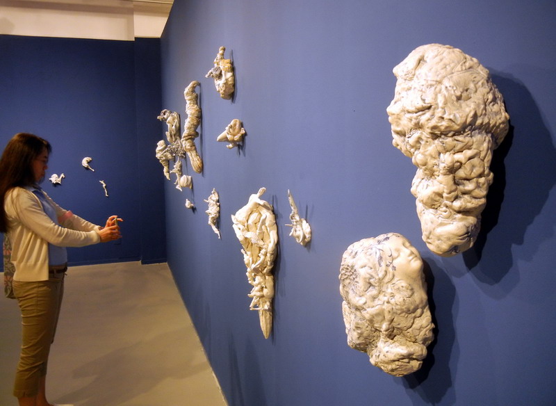 Une visiteuse admire une œuvre en céramique de l'artiste norvégienne Irene Nordli intitulée « Je fais tous mes efforts pour le chercher », au Musée d'Art du Lac Jinji de Suzhou, le 24 mai 2014. [Photo Wang Jiankang / asianewsphoto.com]