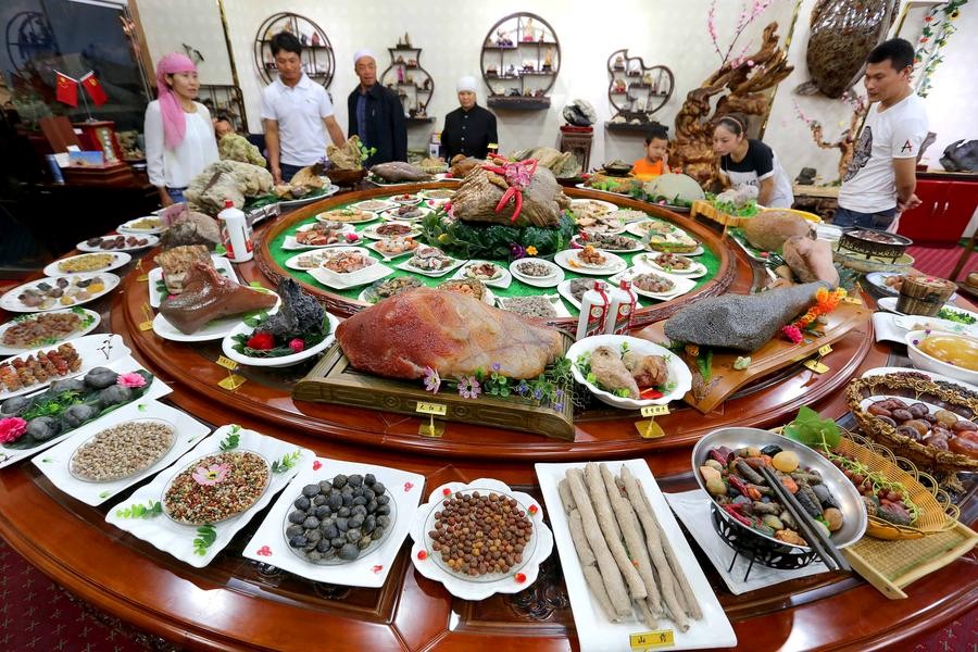 Des visiteurs admirent des plats faits en pierre lors d’une exposition dans la préfecture de Hami, lundi dans la Région autonome ouïgoure du Xinjiang. [Photo / Xinhua] 