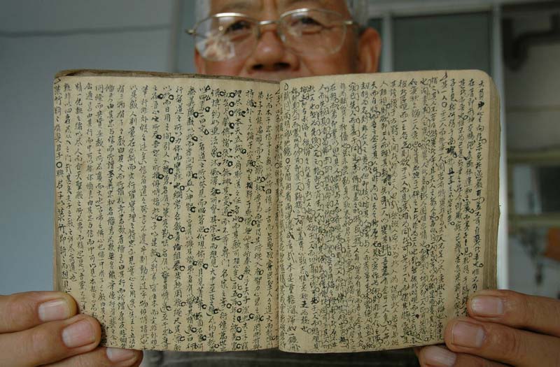 Un homme montre un carnet utilisé pour aider quelqu'un à tricher lors de l'examen impérial dans la Chine ancienne. [Photo / IC]