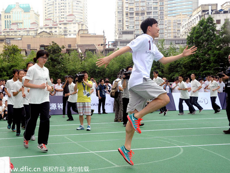 Ancien recordman du monde du 110m haies, le Chinois Liu Xiang à l’échauffement avant de montrer ses talents, lors d’une activité d’enseignement dans un lycée de Shanghai, le 9 juin 2014. [Photo/IC]