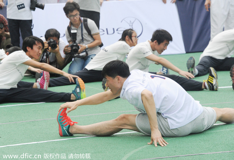 Ancien recordman du monde du 110m haies, le Chinois Liu Xiang à l’échauffement avant de montrer ses talents, lors d’une activité d’enseignement dans un lycée de Shanghai, le 9 juin 2014. [Photo/IC]