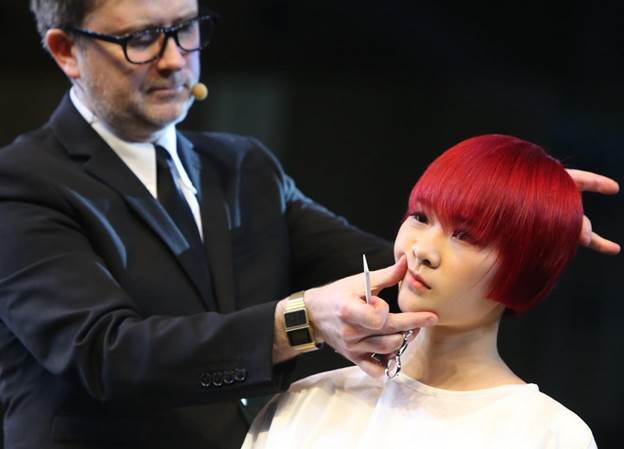 Un coiffeur travaille sur la chevelure d'un mannequin lors de la 9e édition du Festival Asiatique de Coiffure, mercredi à Shanghai. Le festival, qui a débuté mercredi et se termine vendredi, propose une série d'événements, comme un concours de coiffure et des sessions de formation. [Photo Gao Erqiang / Asianewsphoto]