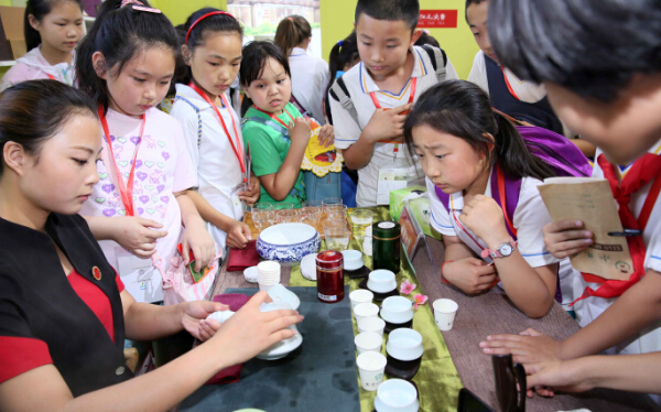 Un spécialiste du thé montre comment faire du thé à un groupe d'élèves à la Foire internationale du thé de cette année le 19 juin à Beijing. [Photo/Asianewsphoto ]
