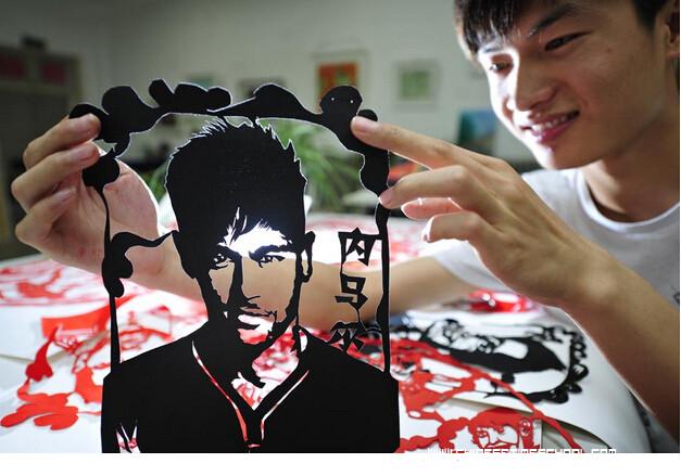 L'Artiste Chang Yangyang montre le portrait du brésilien Neymar Jr qu'il a réalisé en papier découpé.