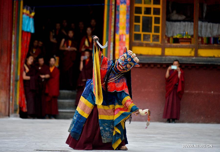 Un lama effectue la danse du sorcier au Temple Drigong Ti, dans le Comté de Maizhokunggar, à Lhassa (Région autonome du Tibet, dans le Sud de la Chine), le 25 juin 2014.