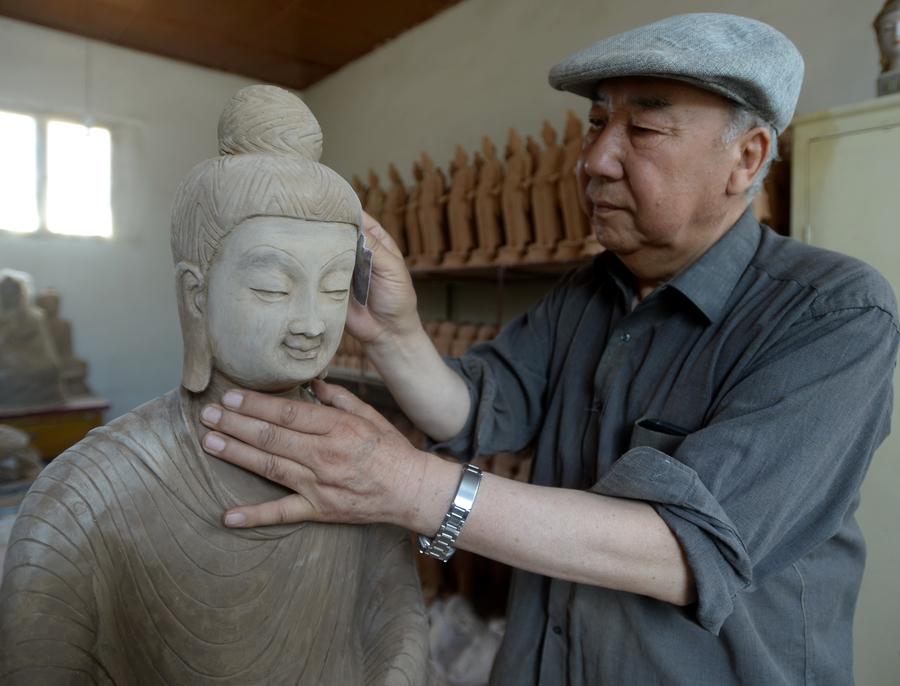 Lu Xueqin polit une statue en argile. 