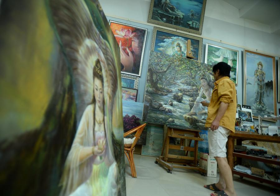 Un peintre a l’œuvre sur un tableau dans un studio de la commune de Yuequan, à Dunhuang, dans la Province du Gansu (Nord-ouest de la Chine), le 27 juin 2014. Attirés par l'art des peintures murales des Grottes de Mogao, de plus en plus de jeunes artistes viennent à Dunhuang pour apprendre la création de peintures murales et ouvrir leurs propres studios. [Photo / Xinhua]