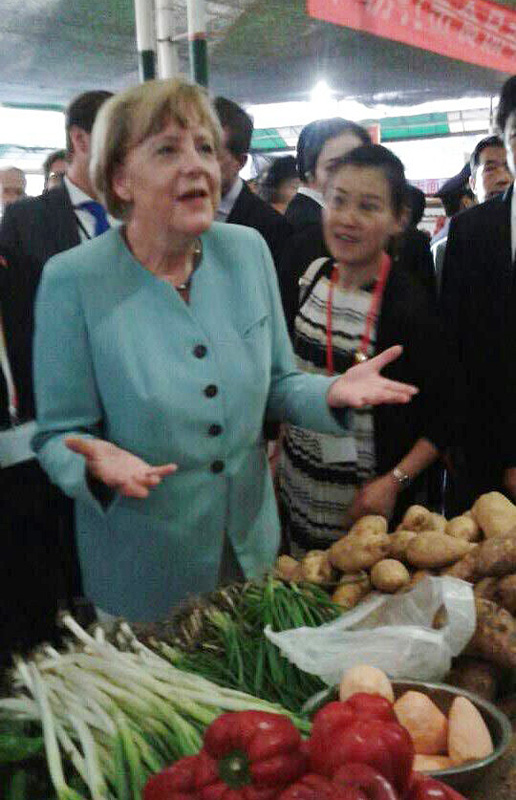 La chancelière allemande Angela Merkel s'est rendue dans un marché ouvert lors de sa visite à Chengdu, la capitale de la province du Sichuan en Chine du Sud-Ouest, le 6 juillet 2014. [Photo: Peng Chao/chinadaily.com.cn]