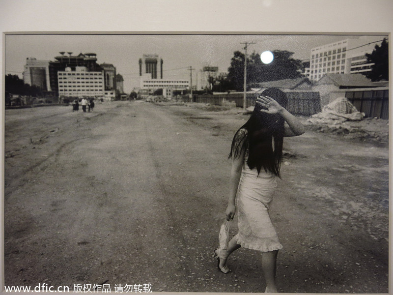 Photo de la série « Underground beijing » par Alain Le Bacquer montrant une fille marchant à l'aube sur une route en construction, de 2001à 2006. [Photo/IC]