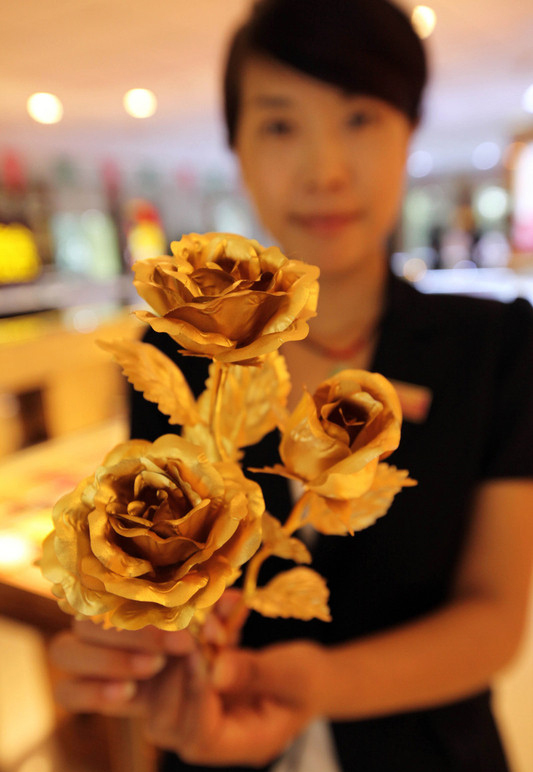 Une vendeuse montre un bouquet de roses en or dans la ville de Lianyungang, dans la Province du Jiangsu, en Chine de l'Est, le 30 juillet 2014. 