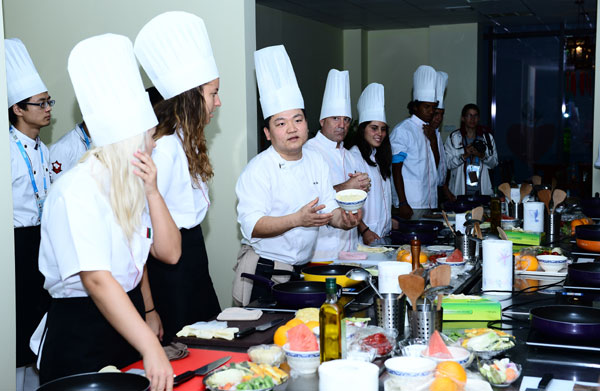 Shi Yi (centre), un chef professionnel chinois, enseigne la cuisine aux athlètes, le 14 août 2014. [Photo/Xinhua ]
