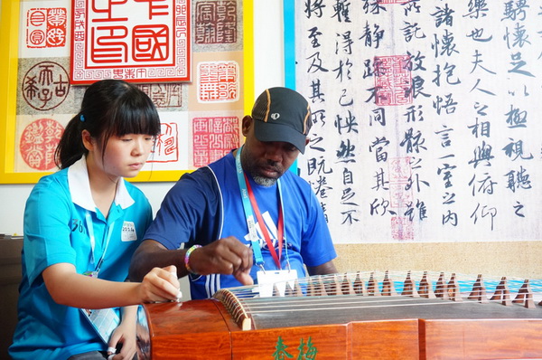 Un officiel du CIO apprend à jouer du « Zheng » chinois.