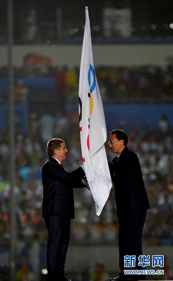 Le maire de Nanjing, Miu Ruilin (droite), transmet le drapeau olympique à Thomas Bach, président du CIO.