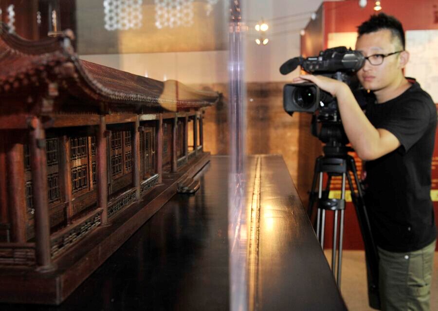 Un caméraman filme une des maquettes en acajou des bâtiments du Yuanmingyuan.
