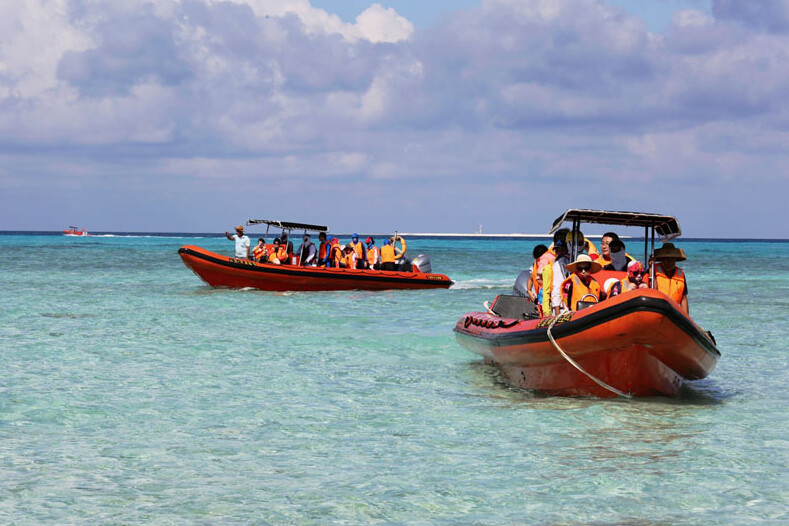 Des touristes prennent des bateaux rapides pour aller aux îles Xisha. [Photo/Xinhua]