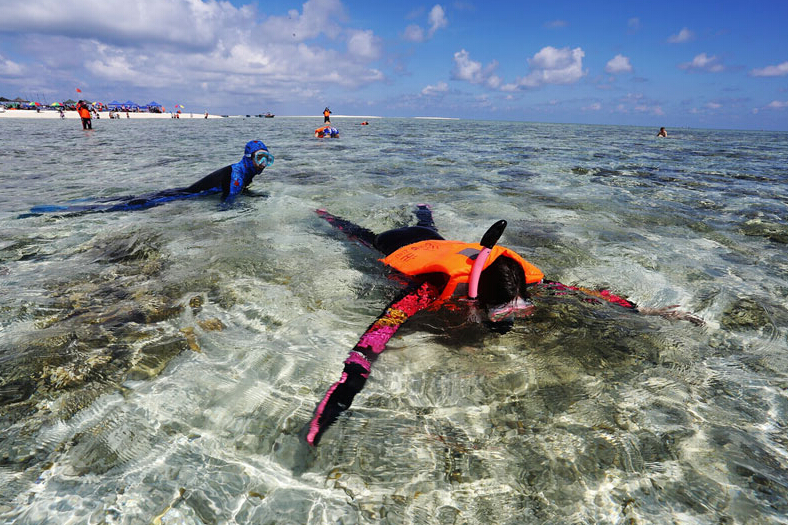 Des touristes essayent de plonger près de la plage de Yinyu. [Photo/Xinhua]