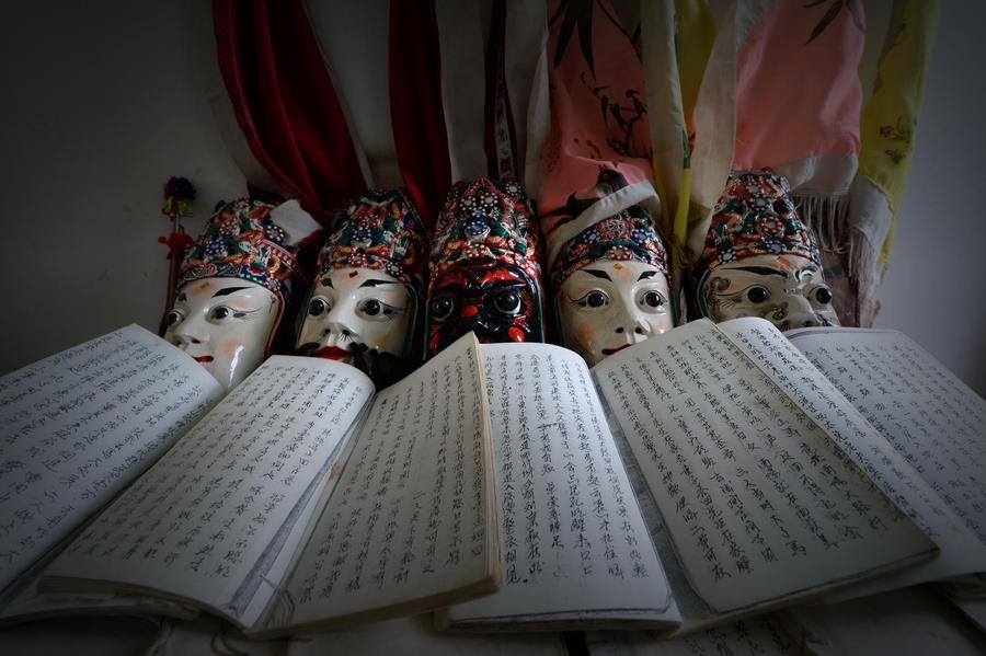 Photo prise le 24 Juillet montre des masques et des textes de l’Opéra d’Anshun, conservés par Zhan Xueyan. [Photo / Xinhua]