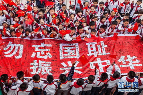 Le 17 septembre à Lianyungang (Province du Jiangsu), les élèves de l'école primaire du District de Ganyu, rue Huanghai, présentent des bannières signées. 