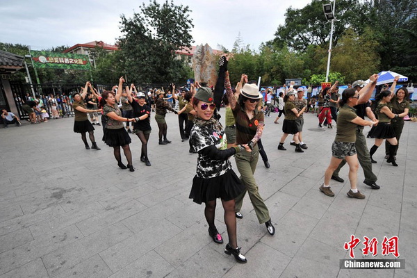 Une fillette se laisse entrainer dans un groupe qui pratique « la danse des zombies ». Photo Jin Shuo pour Xinhua. 