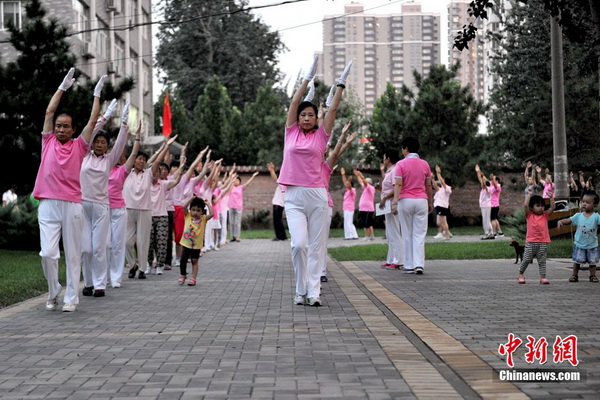 Sur un espace libre d’une résidence de la rue Guangqu, les habitants se rassemblent en un groupe bien aligné pour pratiquer la « danse des zombies ». Nombre de ces amis de la danse s’habillent de manière uniforme, et à côté d’eux quelques  enfants ont également rejoint l'équipe pour se joindre à la fête. Photo Jin Shuo pour Xinhua.