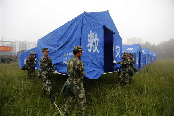 Des secouristes installent des tentes sur les lieux de l'épicentre du tremblement de terre, dans la commune de Yongping (Comté de Jinggu, ville de Pu'er), dans la province du Yunnan (Sud-ouest de la Chine), le 8 octobre 2014 après qu’un séisme de magnitude 6,6 ait secoué Jinggu mardi à 21h49 (13h49 GMT).