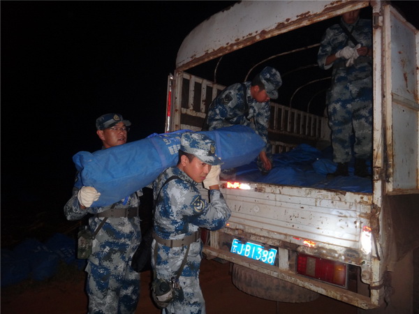 Des secouristes déchargent du matériel dans le village de Mangla.