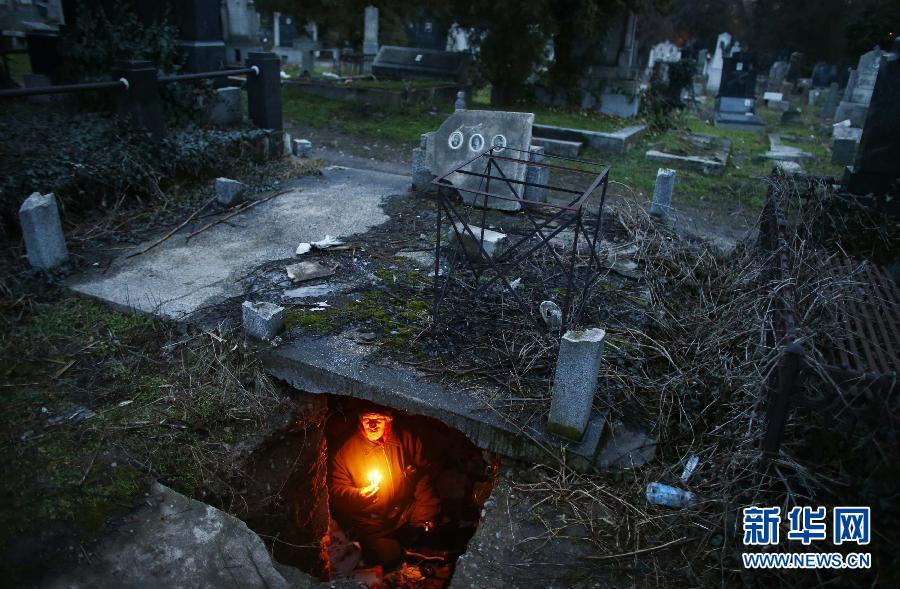 Le 9 février 2013, en Serbie, un sans-abri tient une bougie allumée dans la tombe où il vit. Il s'est installé ici il y a 15 ans déjà. 