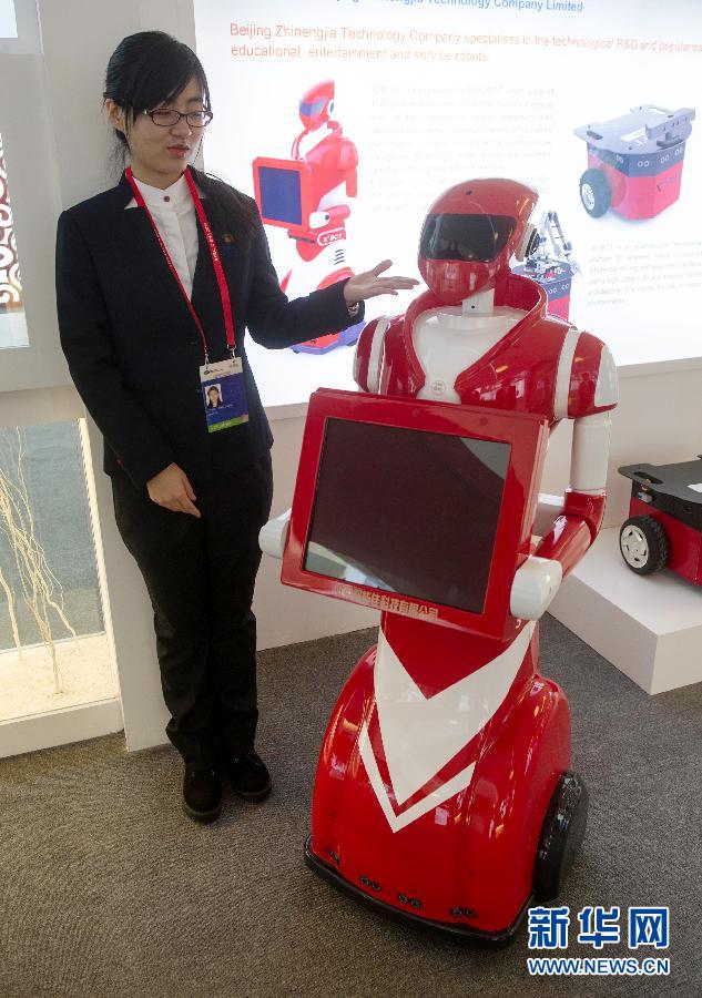 Une volontaire présente un robot chargé de l’accueil, le 7 novembre.