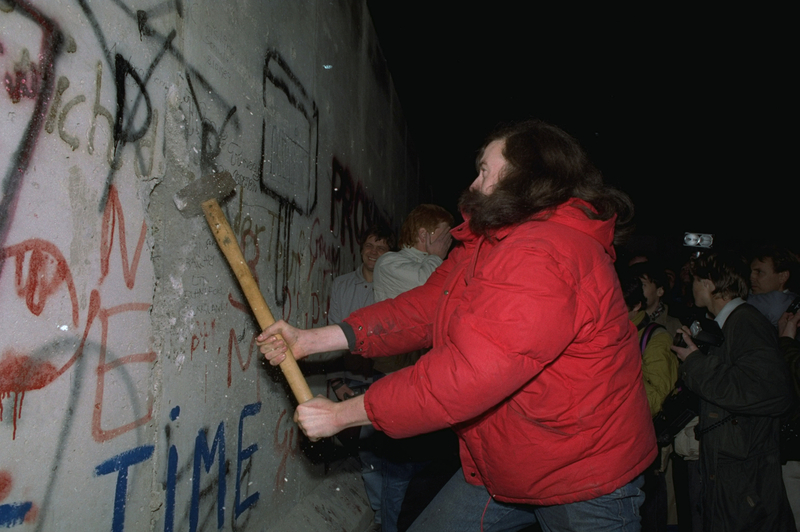 Un berlinois non identifié tente en vain de détruire un segment du mur de Berlin avec un marteau, le 11 novembre 1989, à la Bernauer Strasse, où la police est-allemande a abattu certaines parties du mur pour y ouvrir un nouveau passage .