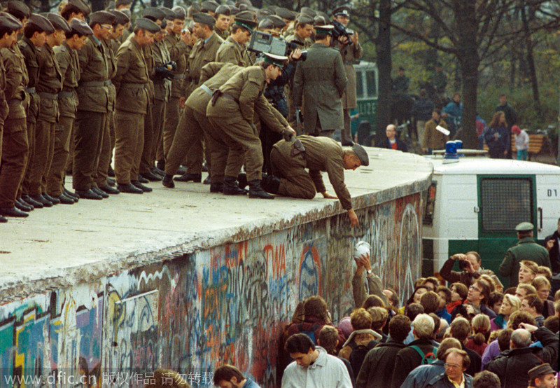 Des citadins de Berlin de l'Ouest donnent du café aux garde-frontières de la RDA sur le mur de Berlin, le 11 novembre 1989. 