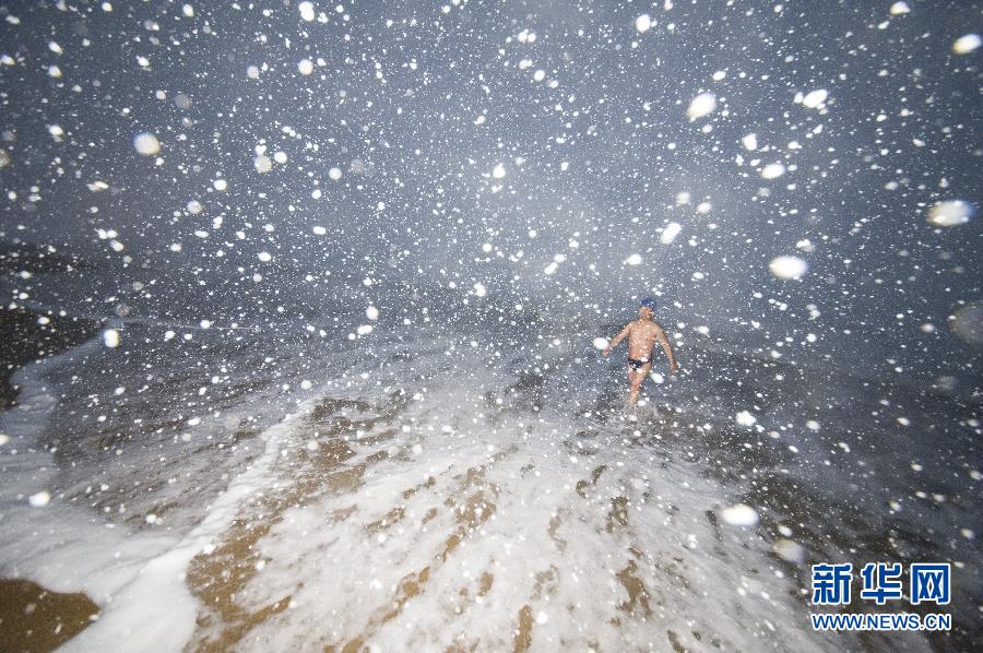 Un amateur de natation d’hiver se dirige vers la mer sous la neige.
