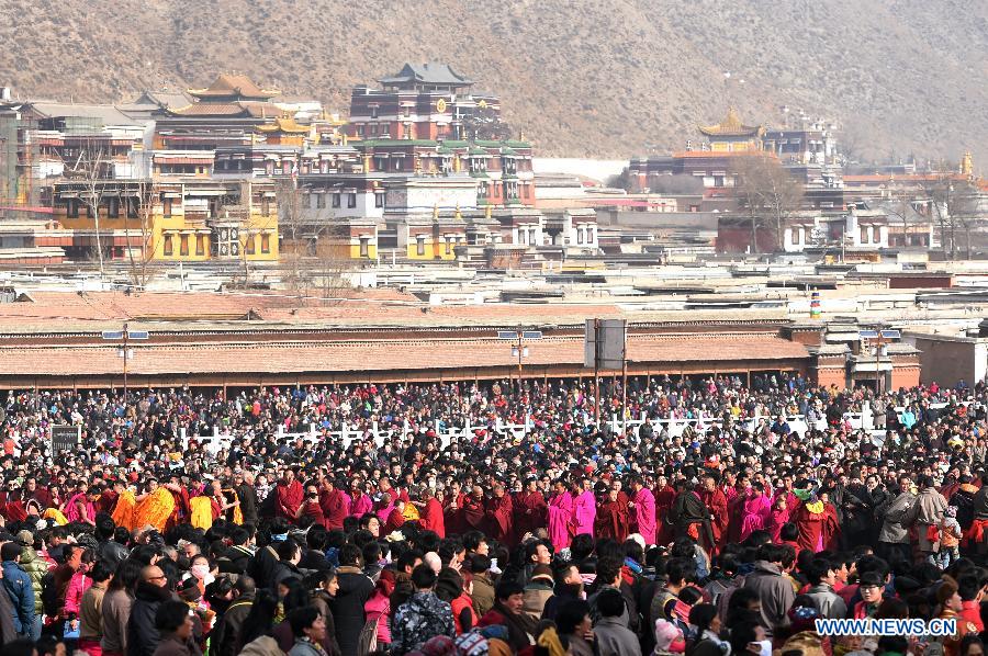Plusieurs lamas et bouddhistes participent au rituel annuel de l'exposition d'une gigantesque thangka (peinture religieuse tibétaine) proche d'une colline pour le culte de disciples au monastère de Labrang à Xiahe, dans la province chinoise du Gansu (nord-ouest de la Chine), le 3 mars 2015. L'événement de la thangka, ou "l'exposition au soleil du Bouddha", lors des traditionnelles prières bouddhistes pour une bonne année. [Photo/Xinhua]