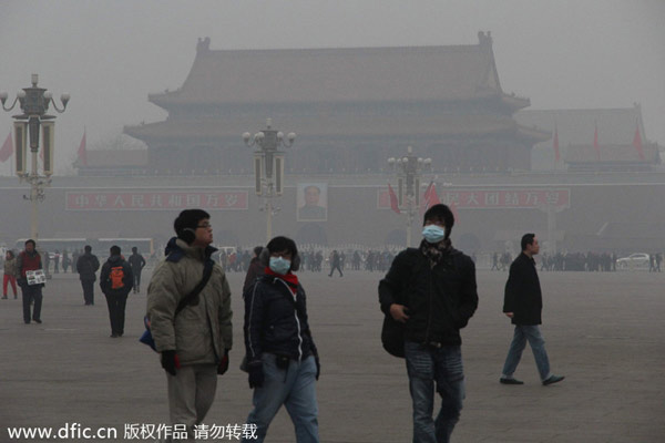Des touristes portant des masques visitent la place Tiananmen enveloppée dans un smog lourd, le 25 février 2014 à Beijing. [Photo / IC]