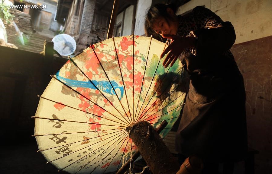Une villageoise fabrique une ombrelle de papier huilé, dans le canton de Fenshuiling de la ville de Luzhou, dans la Province du Sichuan (Sud-ouest de la Chine), le 12 avril 2015.