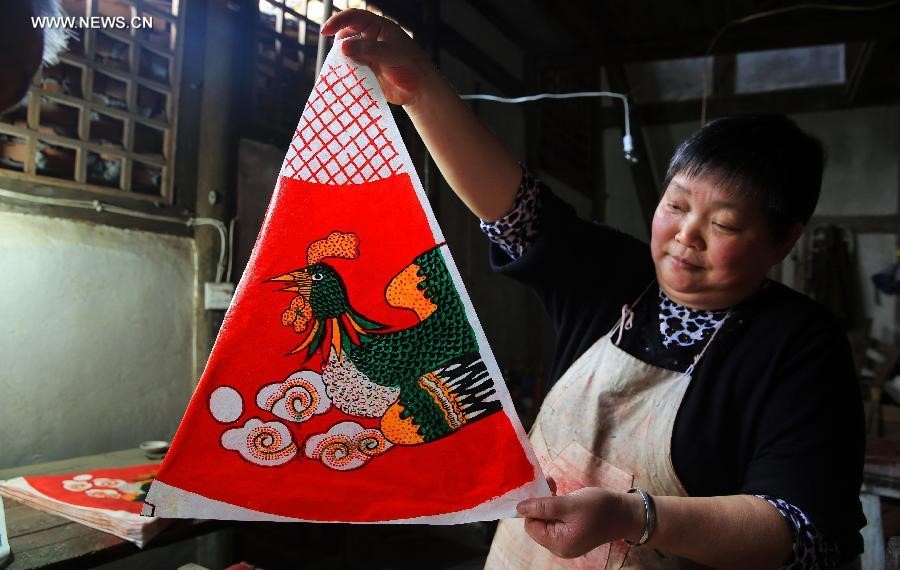 Une villageoise montre la couverture d’une ombrelle, dans le canton de Fenshuiling de la ville de Luzhou, dans la Province du Sichuan (Sud-ouest de la Chine), le 12 avril 2015.