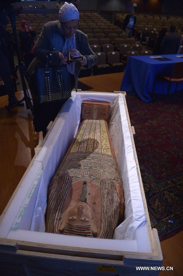 Une femme prend un vidéo du sarcophage d'Egypte dans la National Geographic Society à Washington D.C., aux États-Unis, le 22 avril 2015. L'Immigration and Customs Enforcement (ICE) des Etats-unis rendent mercredi de nombreux d'objets au gouvernement de l'Egypte lors d'une enquête à New York. (Xinhua/Yin Bogu)   