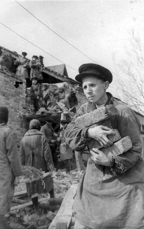 Des élèves participent à la reconstruction de leur école, en 1943.