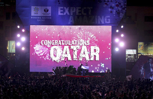 Des gens font la fête en face d'un écran où on peut lire « Félicitations au Qatar » après que la FIFA ait annoncé que le Qatar sera l'hôte de la Coupe du Monde 2022 à Souq Waqif, à Doha (photo d’archives du 2 décembre 2010). [Photo / Agences]