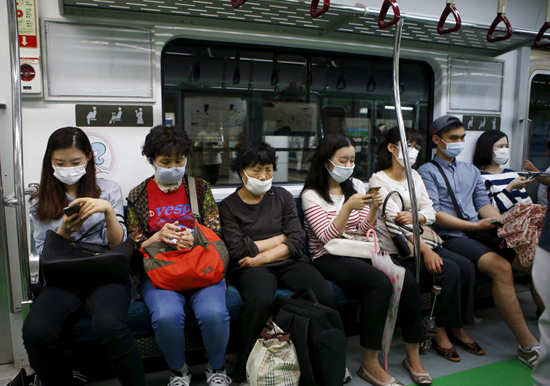 Des passagers du métro de Séoul portent des masques pour se protéger