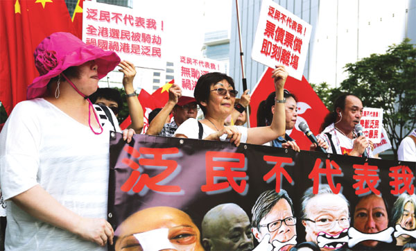 Plusieurs banderoles condamnant l'opposition lors d'un rassemblement jeudi en faveur de la réforme électorale à l'extérieur des bureaux du gouvernement central. (Parker Zheng/China Daily)