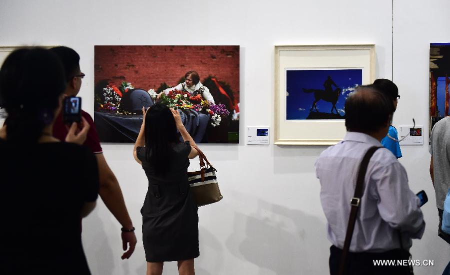 Les gens visitent l'exposition de photographie "La guerre et la paix" à l'Université de Wuhan, dans la province du Hubei (centre de la Chine), le 22 juin 2015. L'exposition dure du 22 juin au 10 juillet pour commémorer le 70e anniversaire de la victoire de la Guerre antifasciste mondiale. (Xinhua/Hao Tongqian)