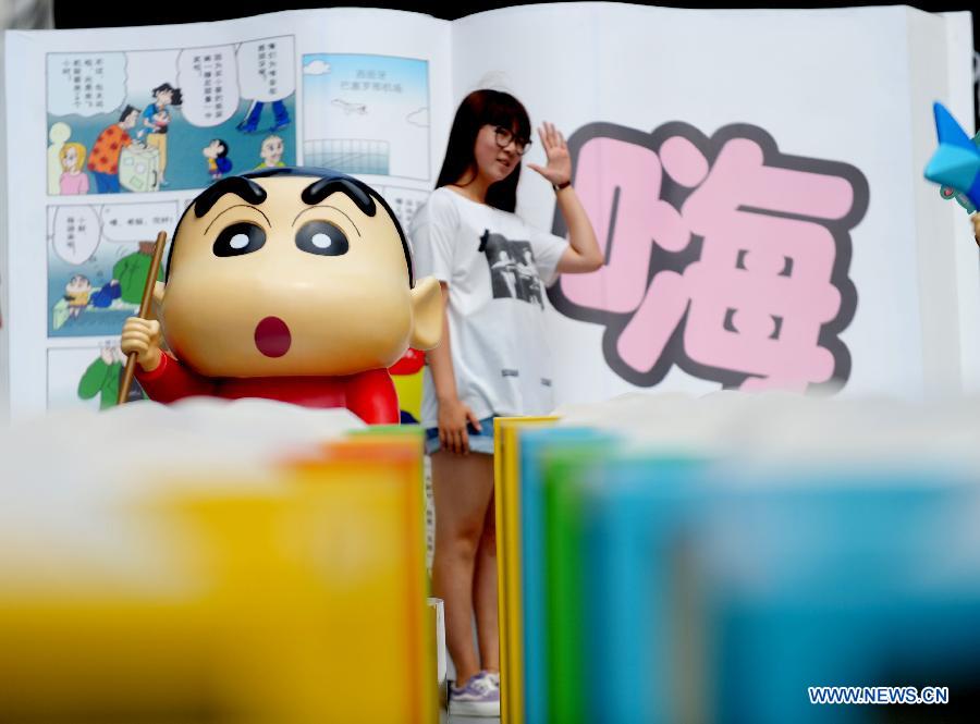 Des gens visitent une exposition pour célébrer le 25ème anniversaire de Crayon Shin-chan, une série japonaise de manga et d'anime créée par Yoshito Usui en 1990, à Shenyang, capitale de la province du Liaoning, le 11 juillet 2015. (Xinhua)