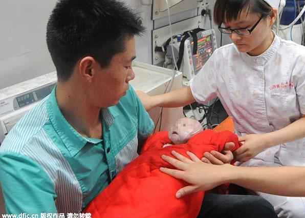 Une infirmière prend soin du bébé dans l'ambulance. [Photo / IC]