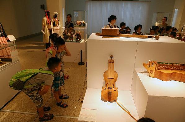 Des visiteurs admirent les œuvres d'art exposées lors de l'exposition Un exemple des œuvres d'art présentées à l'exposition « Des sources à l'inspiration : les motifs ethniques dans le design polonais ». [Photo / namoc.org], le 30 juillet. [Photo Jiang Dong / asianewsphoto.com]