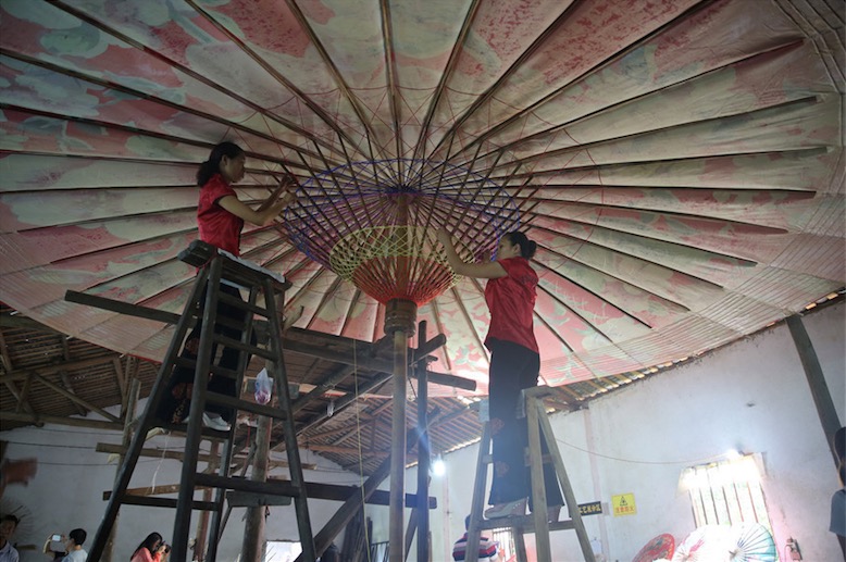 Fabrication de parapluies de papier huilé dans le comté de Fenshui à Luzhou, la province chinoise du Sichuan (sud-ouest du pays), le 6 août 2015.