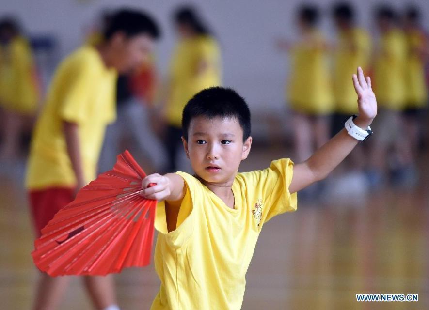 Des jeunes apprennent le tai-chi Kung Fu Fan pendant leur camp d'été