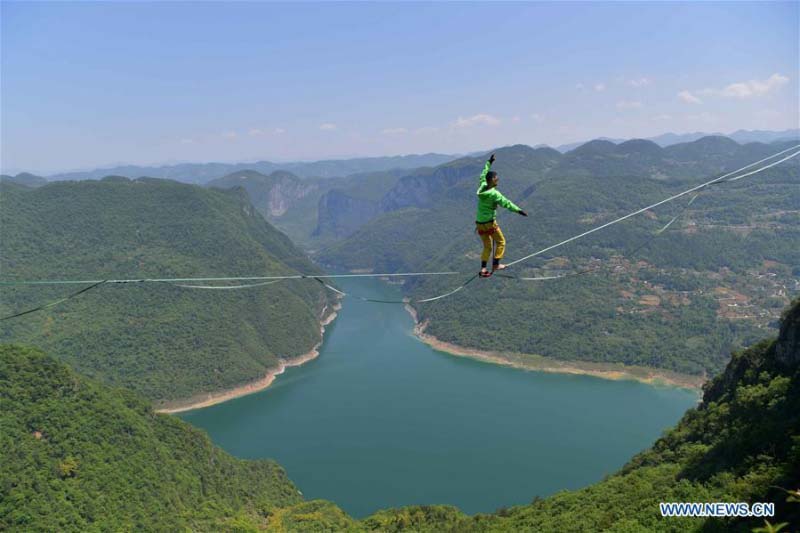Homme fait de l'équilibre sur un fil dans une base de sports de plein air au Hubei